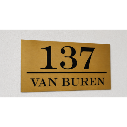 Goudkleurig ABS huisnummerbord met zwarte kern, gepersonaliseerd met lasergegraveerd huisnummer en familienaam.