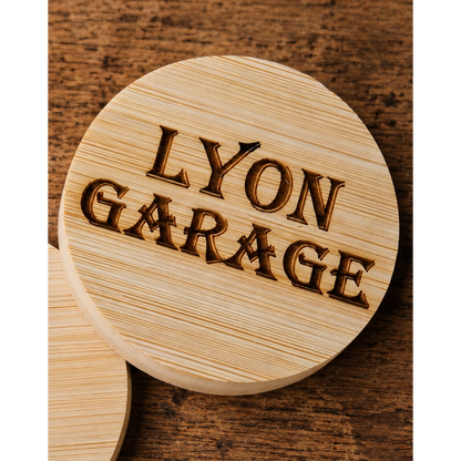 Detail van een ronde bamboe flesopener met nauwkeurig lasergegraveerd logo, personaliseerbaar met eigen ontwerp.