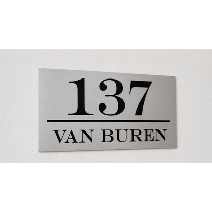 Zilverkleurig ABS huisnummerbord met zwarte kern en lasergegraveerd huisnummer en familienaam.